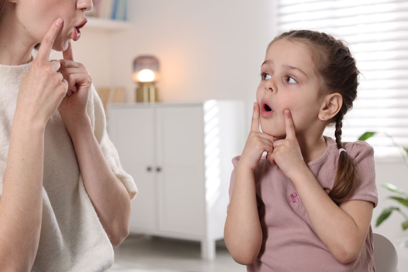 Criança pequena conversando com a mãe durante uma brincadeira em casa